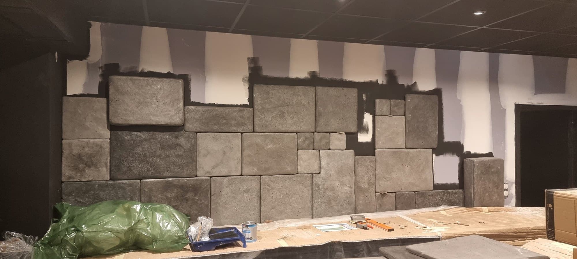 Les premières pierres moulées posées sur le mur