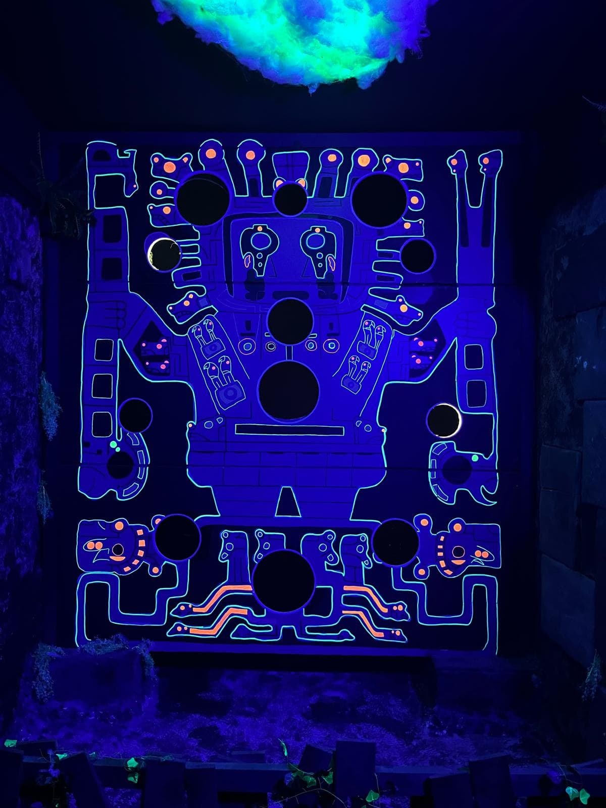 Le mur de jeu de la salle de la Foudre et son nuage, sous lumière noire